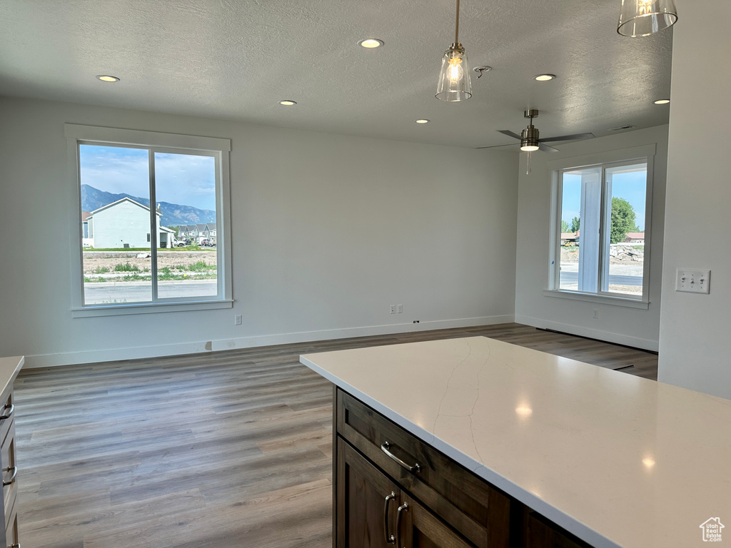 Kitchen with healthy amount of natural light, recessed lighting, a textured ceiling, light wood finished floors, and light countertops