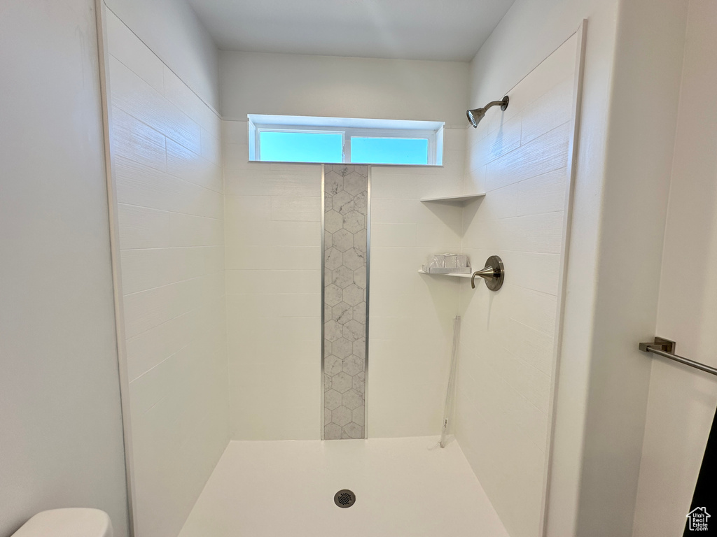 Full bathroom with tiled shower and toilet