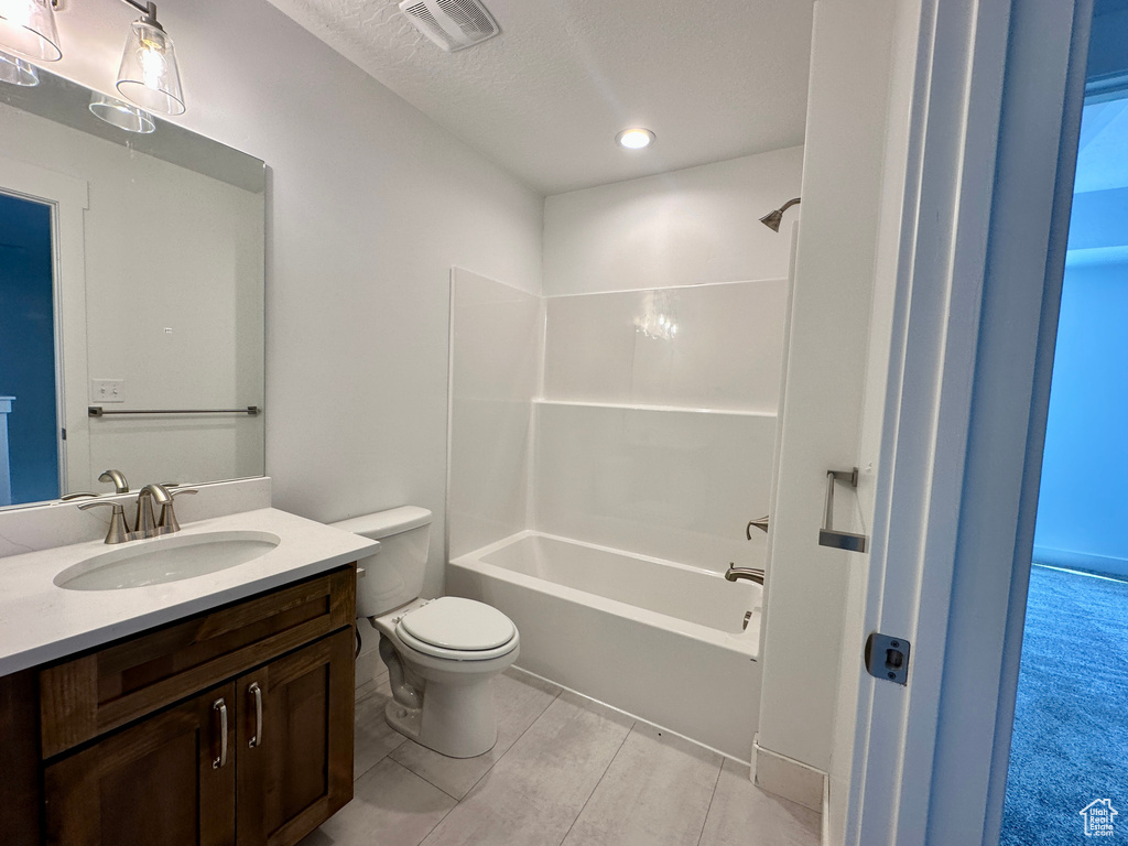 Full bath with vanity, shower / bathtub combination, a textured ceiling, and recessed lighting