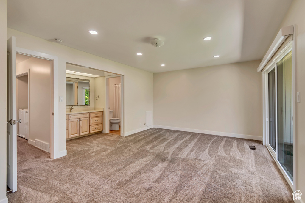 Unfurnished bedroom featuring light carpet, recessed lighting, baseboards, a sink, and ensuite bathroom