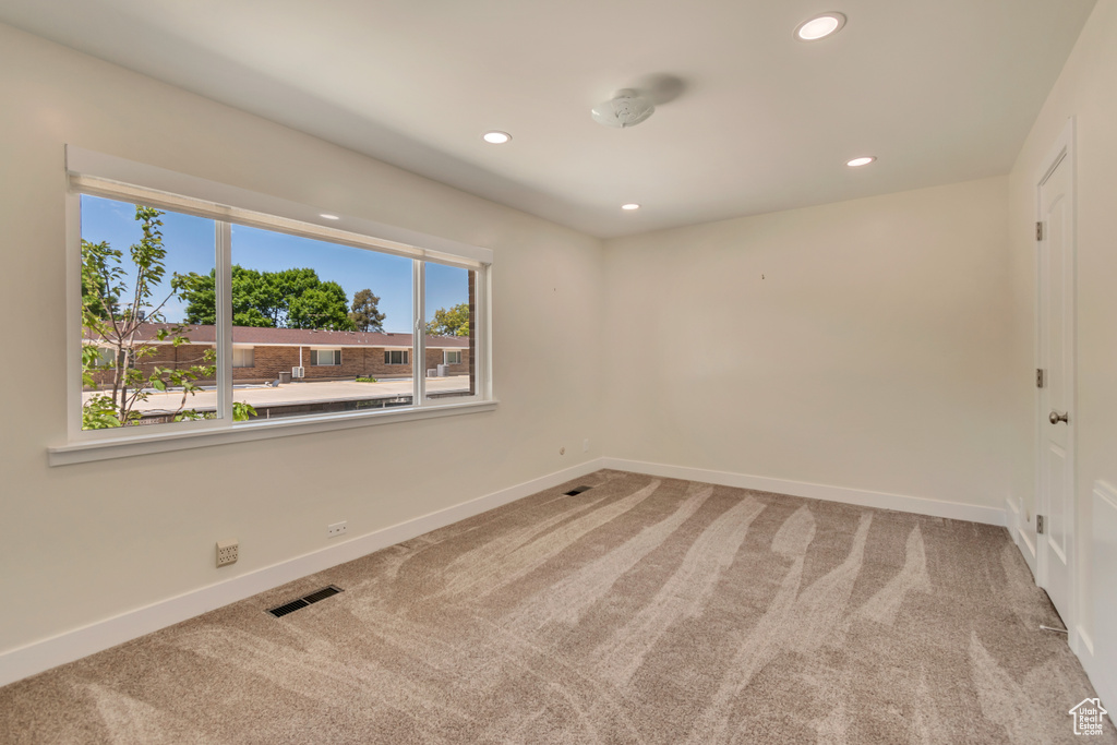 Carpeted empty room featuring baseboards and recessed lighting