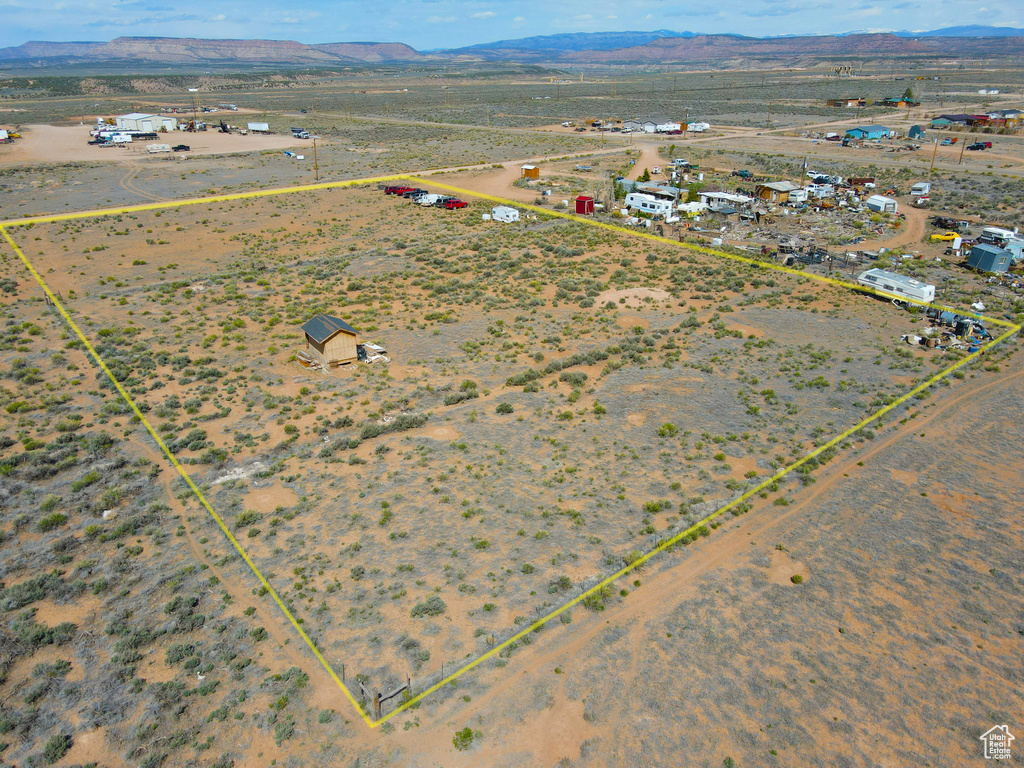 Aerial overview of property's location with property boundaries highlighted, a mountainous background, and a desert landscape