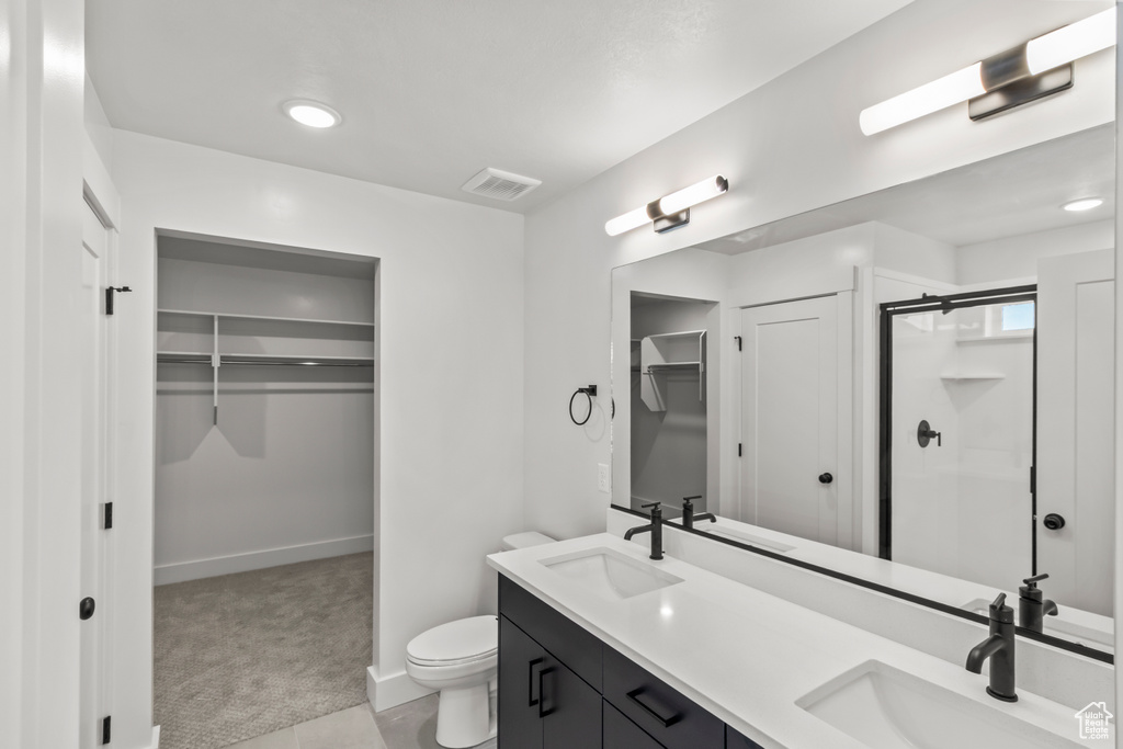 Bathroom with toilet, a stall shower, a sink, and baseboards