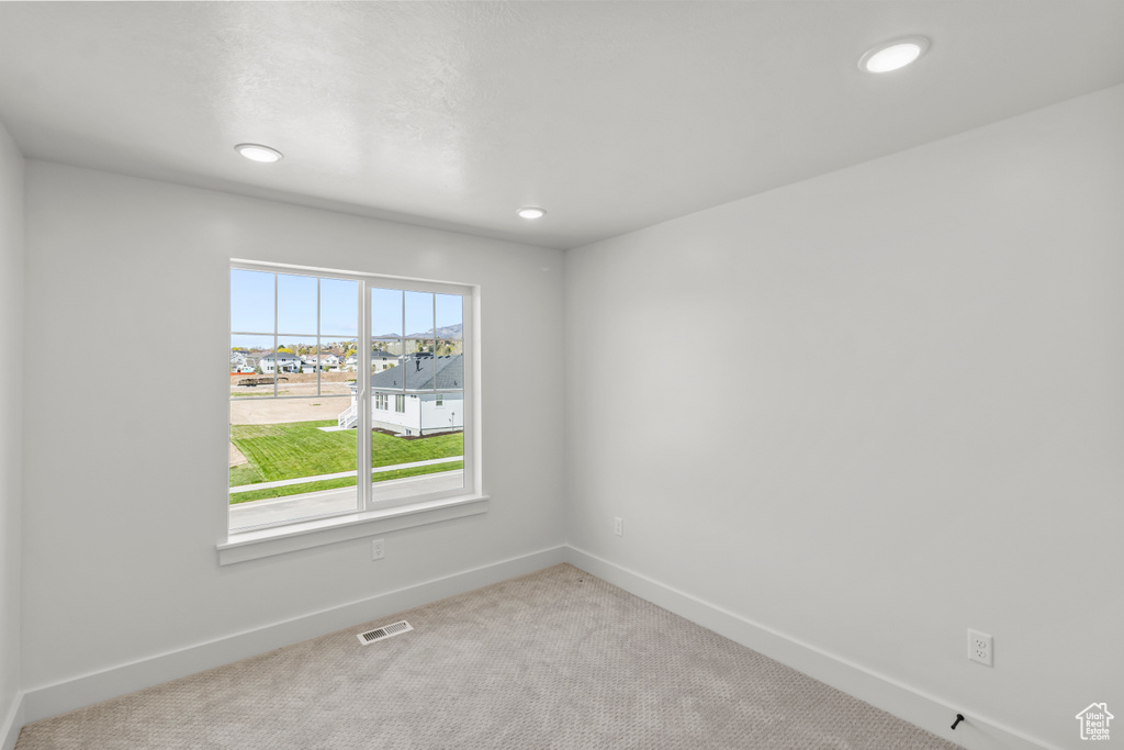 Empty room featuring recessed lighting, visible vents, carpet, and baseboards