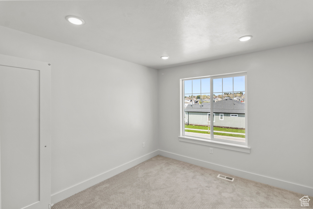 Spare room featuring carpet flooring, recessed lighting, visible vents, and baseboards