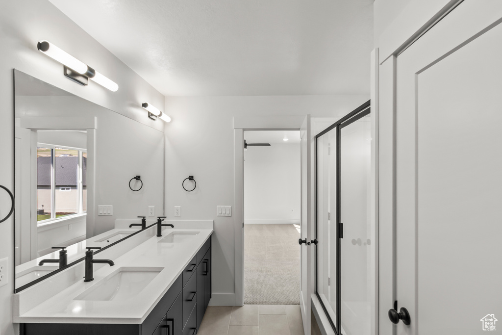 Full bathroom with tile patterned flooring, a sink, a shower stall, and double vanity