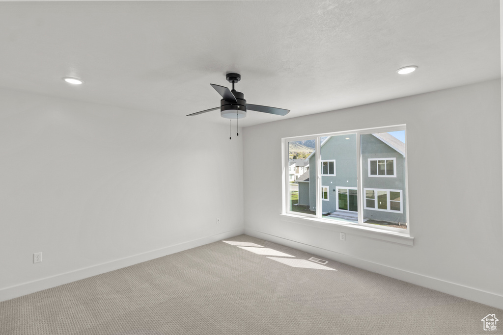 Spare room featuring baseboards, recessed lighting, ceiling fan, and carpet floors