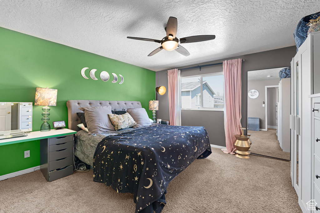 Bedroom featuring baseboards, a ceiling fan, carpet flooring, and a textured ceiling