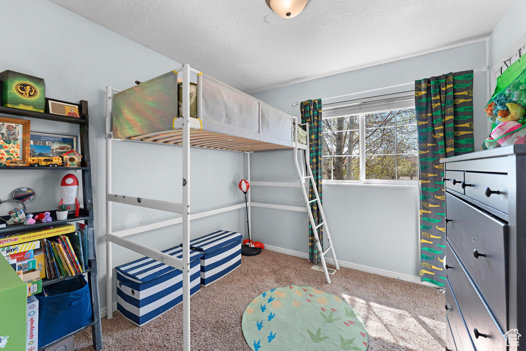 Bedroom with baseboards, carpet flooring, and a textured ceiling