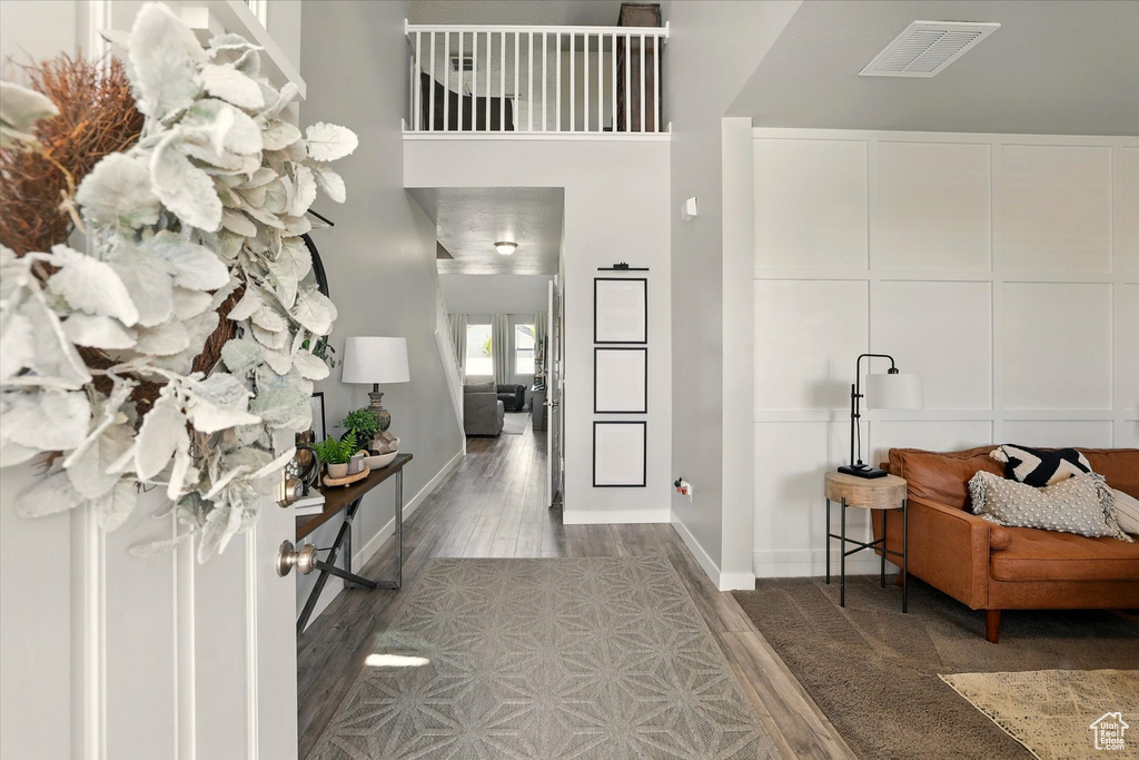 Entrance foyer featuring wood finished floors, baseboards, and a high ceiling