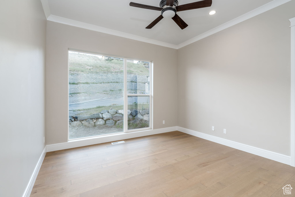 Empty room featuring a ceiling fan, baseboards, crown molding, light wood-style flooring, and recessed lighting