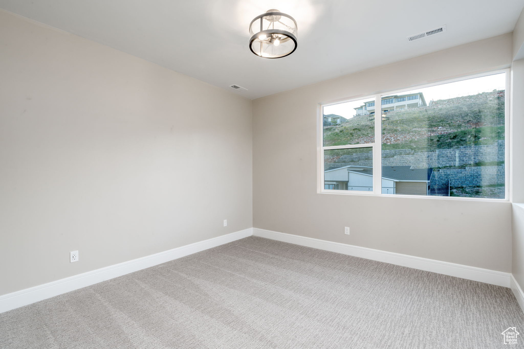 Carpeted empty room with baseboards