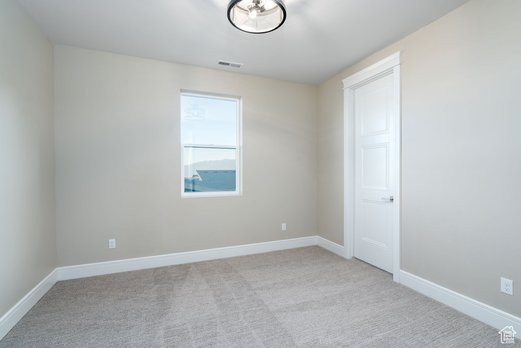 Carpeted empty room with baseboards