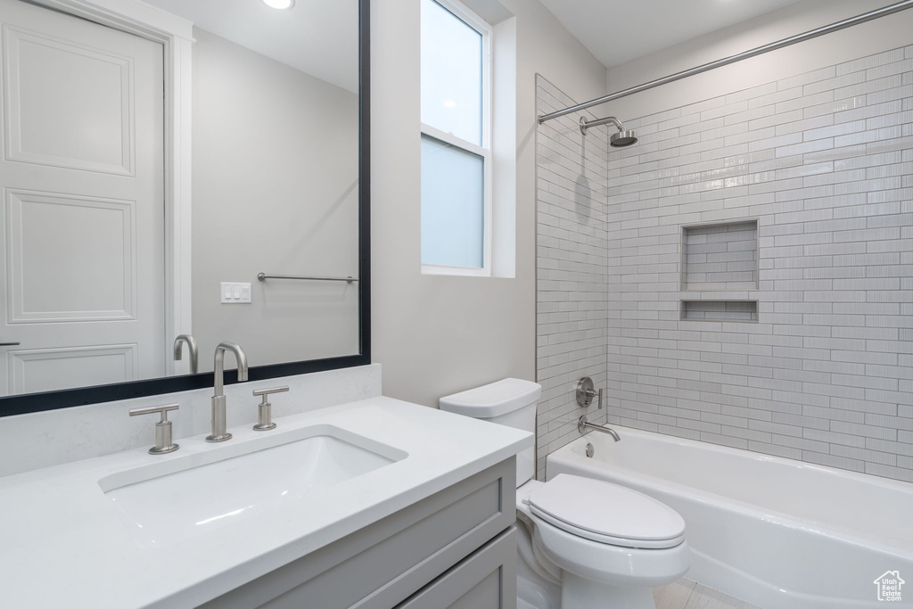 Bathroom featuring toilet, washtub / shower combination, and vanity