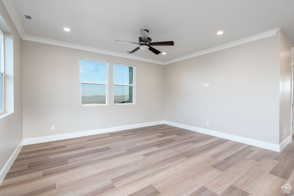Empty room featuring a ceiling fan, recessed lighting, light wood finished floors, baseboards, and crown molding