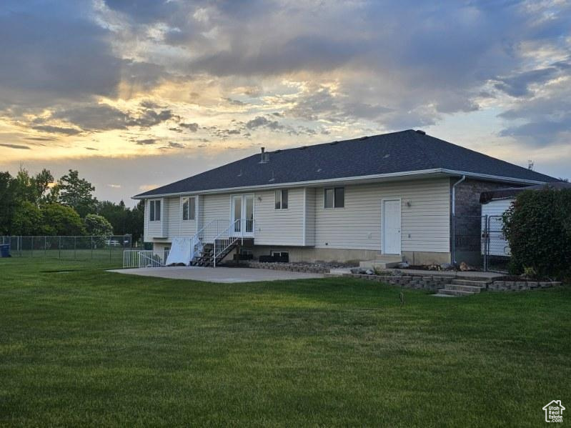 Back of property at dusk with a patio, french doors, and entry steps