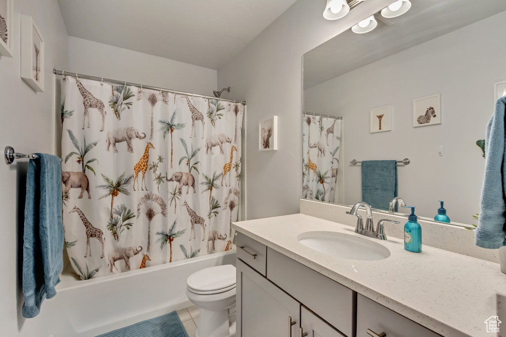 Bathroom featuring toilet, vanity, tile patterned flooring, and shower / tub combo with curtain
