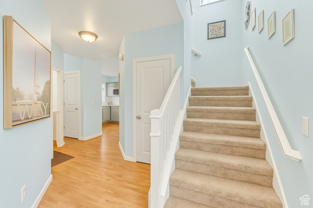 Stairway with baseboards and wood finished floors