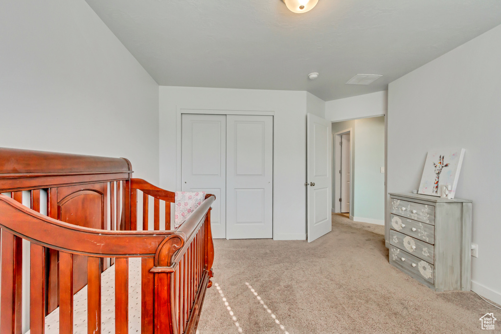 Carpeted bedroom featuring a closet and baseboards