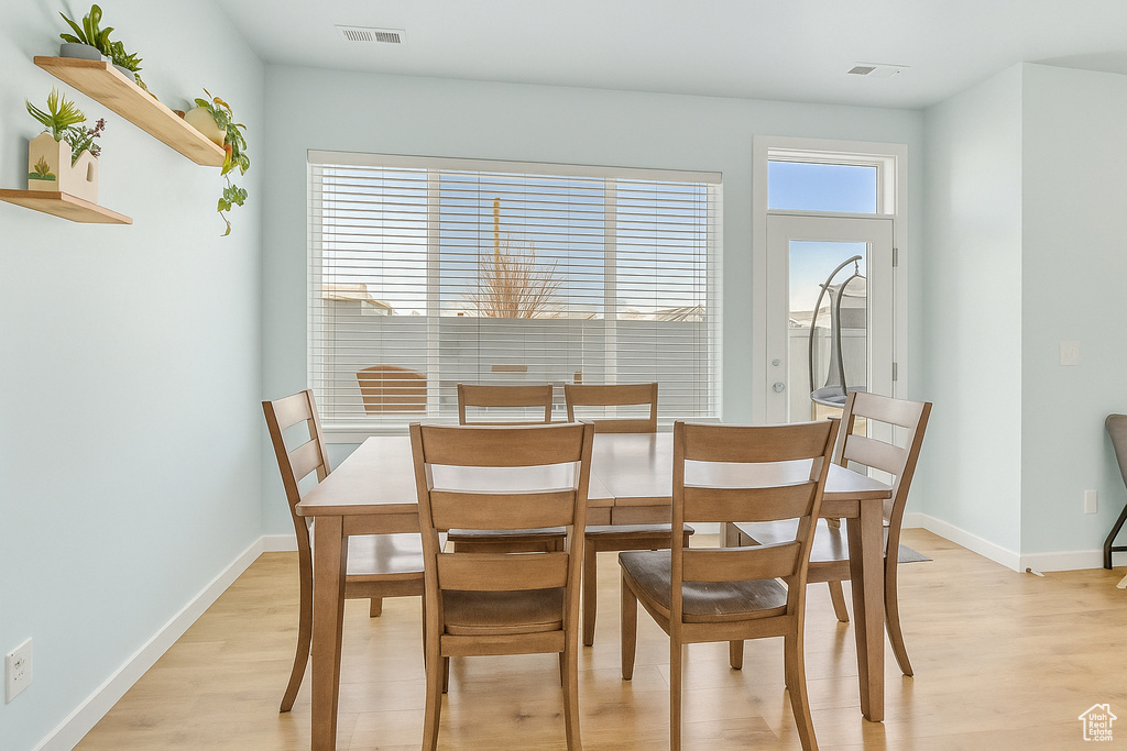 Dining space featuring baseboards, visible vents, and light wood-style floors