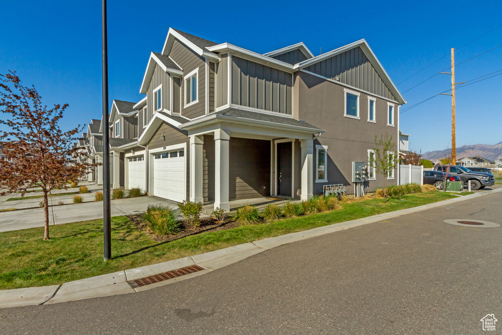 View of front of house featuring board and batten siding, a garage, and concrete driveway