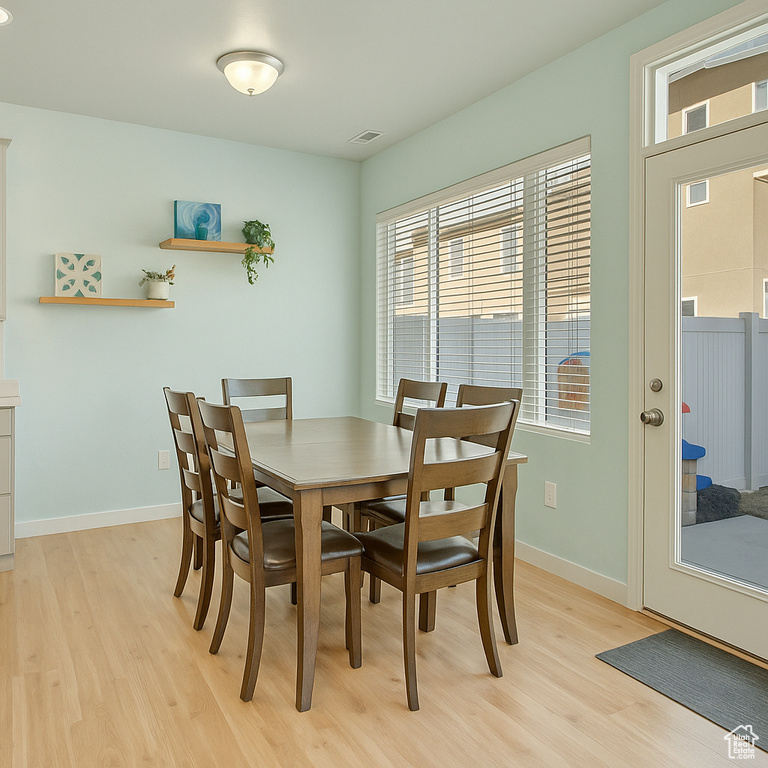 Dining space with baseboards, visible vents, and light wood-style floors