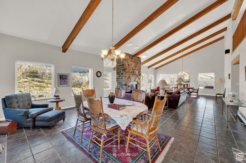 Dining area featuring baseboards, high vaulted ceiling, an inviting chandelier, and beam ceiling