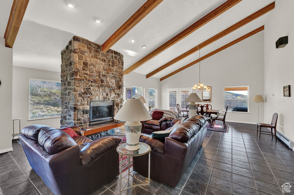 Living room with a notable chandelier, a fireplace, high vaulted ceiling, baseboards, and beamed ceiling