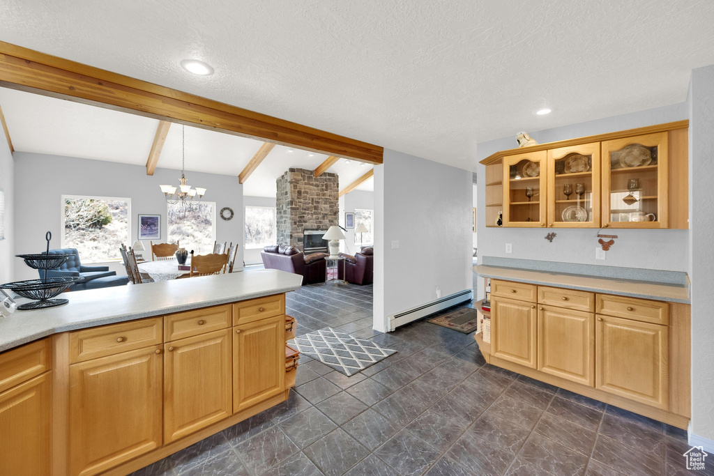 Kitchen with light countertops, baseboard heating, a fireplace, and glass insert cabinets