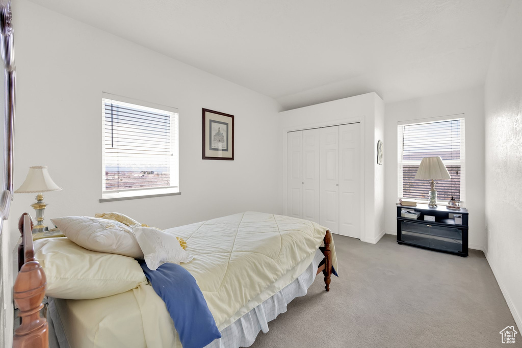 Carpeted bedroom with baseboards and a closet