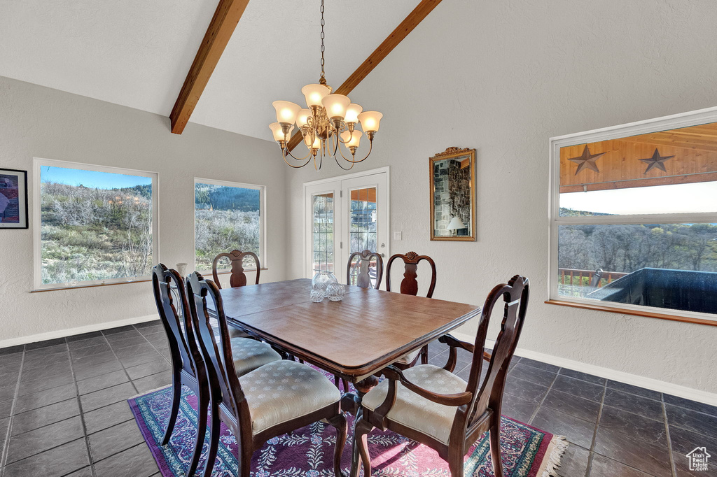 Dining room featuring an inviting chandelier, baseboards, a textured wall, and beam ceiling