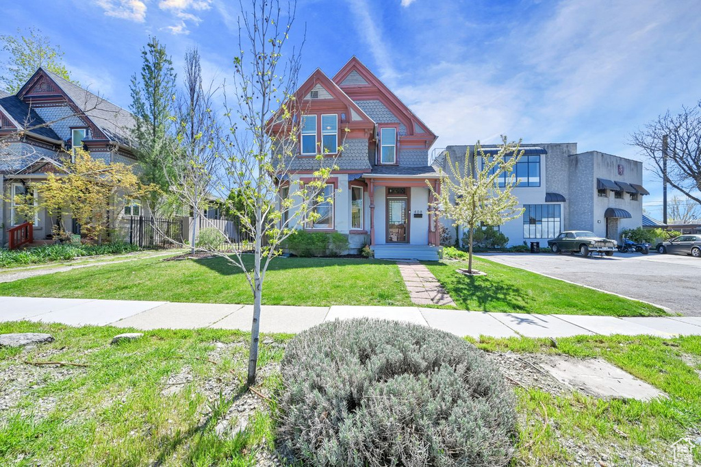 View of front of home featuring a front yard and fence