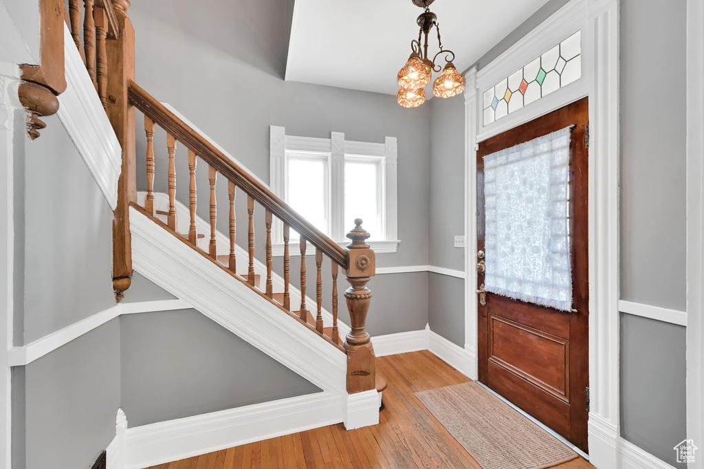 Entryway featuring baseboards, wood finished floors, and stairs