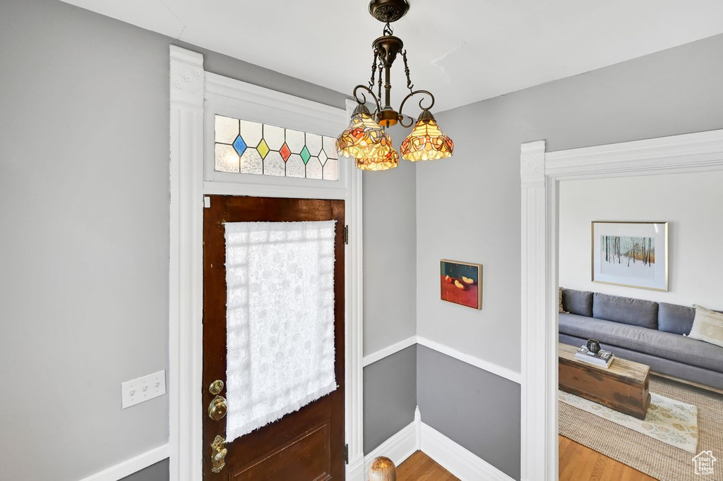 Foyer with baseboards and wood finished floors
