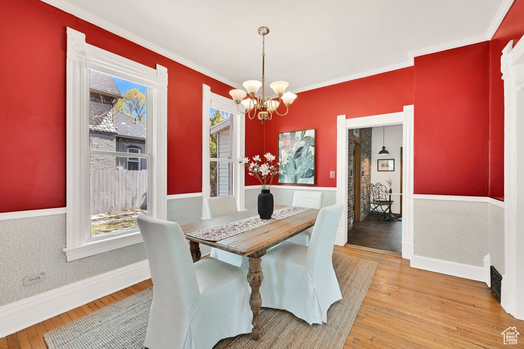 Dining space with light wood-style flooring, plenty of natural light, a chandelier, and baseboards