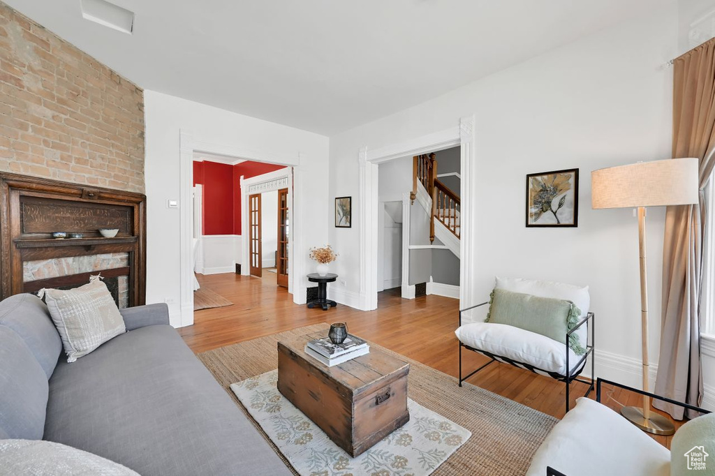 Living area with baseboards, stairway, and wood finished floors
