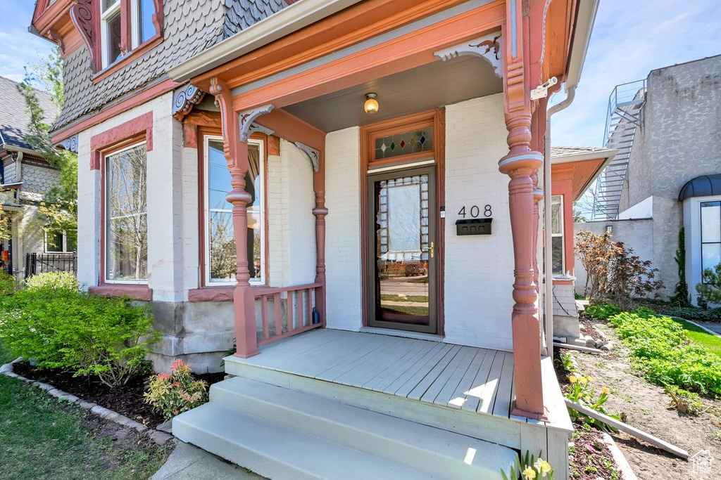 Entrance to property featuring brick siding and a porch