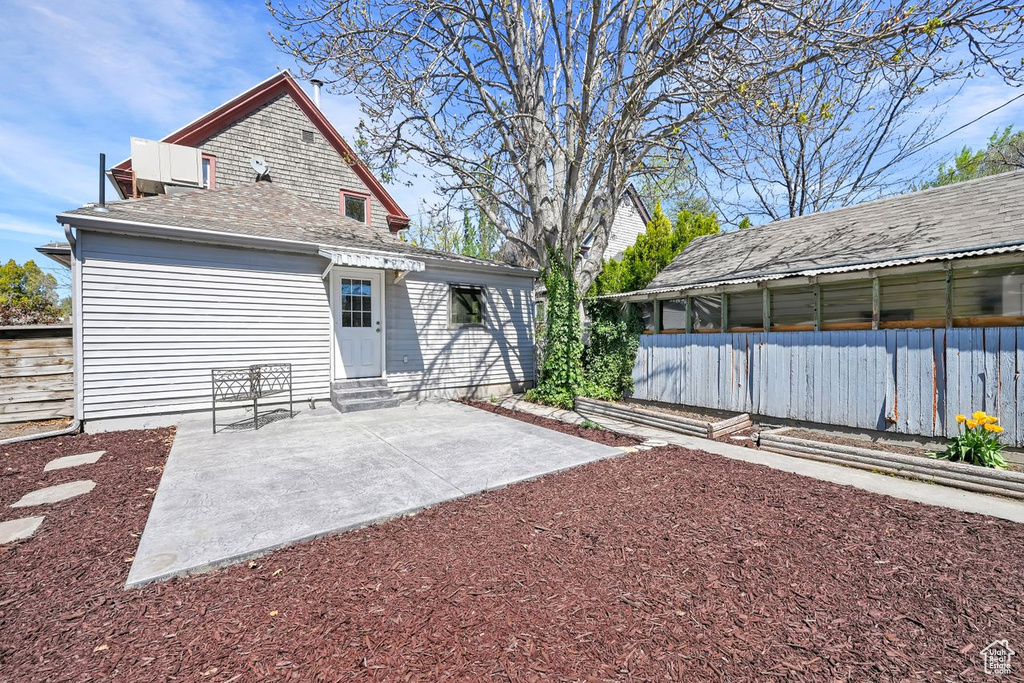 Rear view of property with entry steps, fence, and a patio