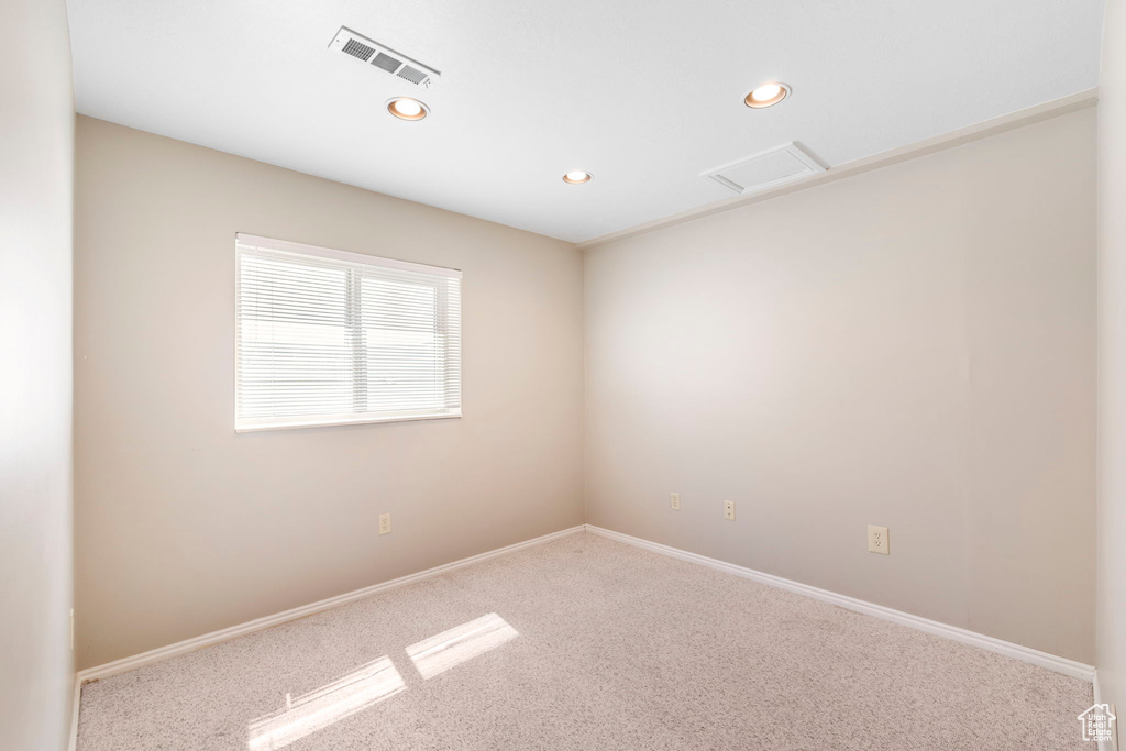 Carpeted empty room featuring visible vents, baseboards, and recessed lighting