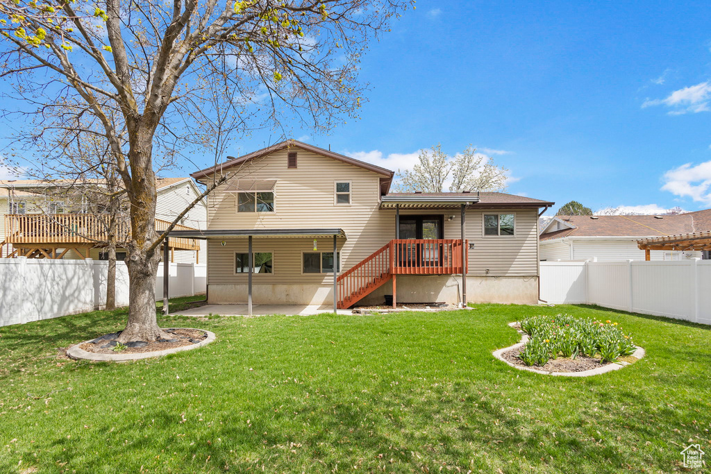 Rear view of property featuring a patio area, a fenced backyard, and a yard