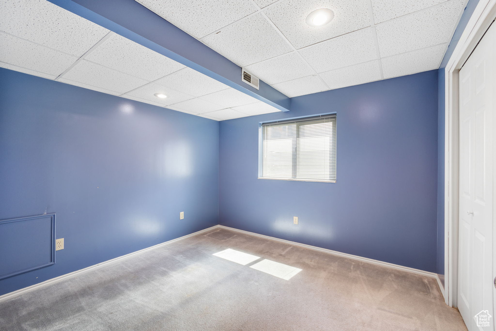 Carpeted spare room featuring a paneled ceiling, baseboards, visible vents, and recessed lighting