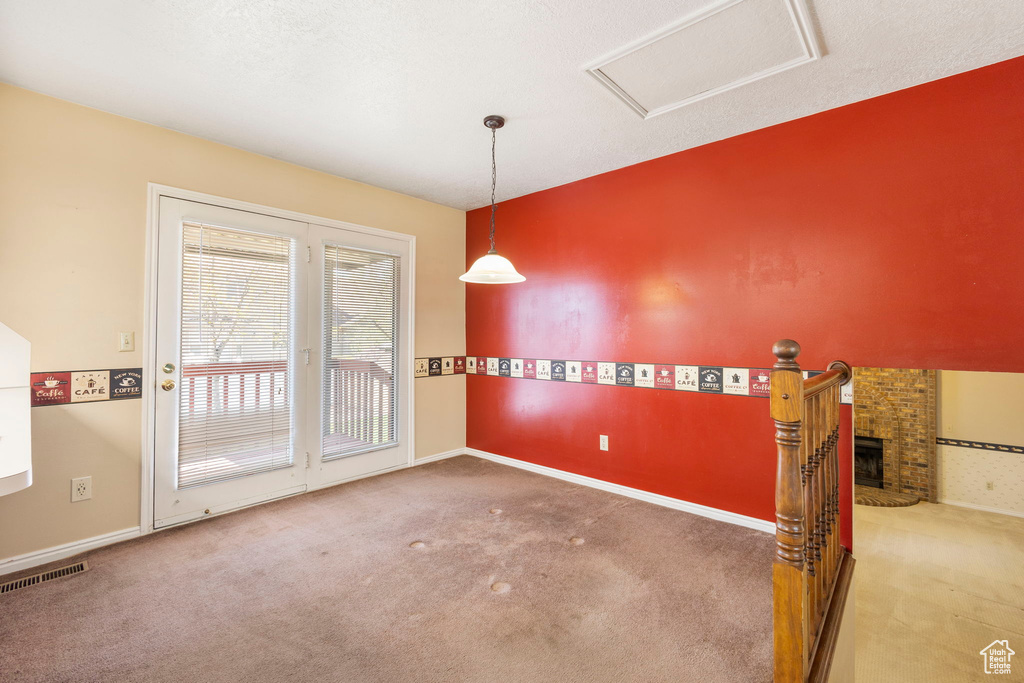 Empty room with attic access, visible vents, and carpet floors