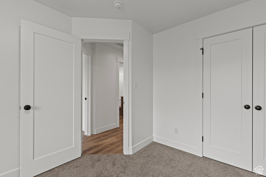 Unfurnished bedroom featuring carpet, baseboards, and a closet