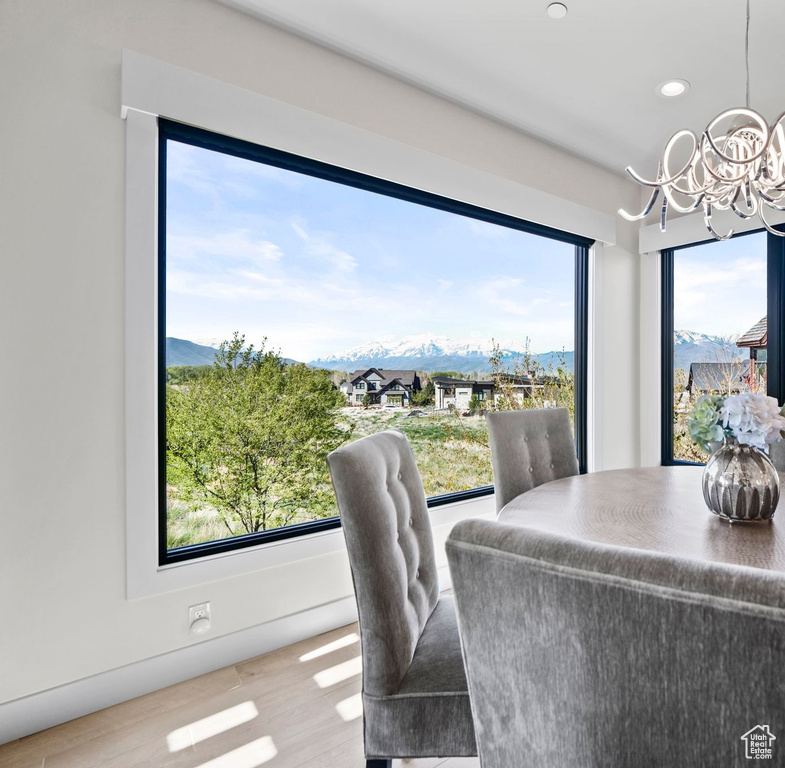 Dining space featuring wood finished floors, a mountain view, a notable chandelier, recessed lighting, and a wealth of natural light