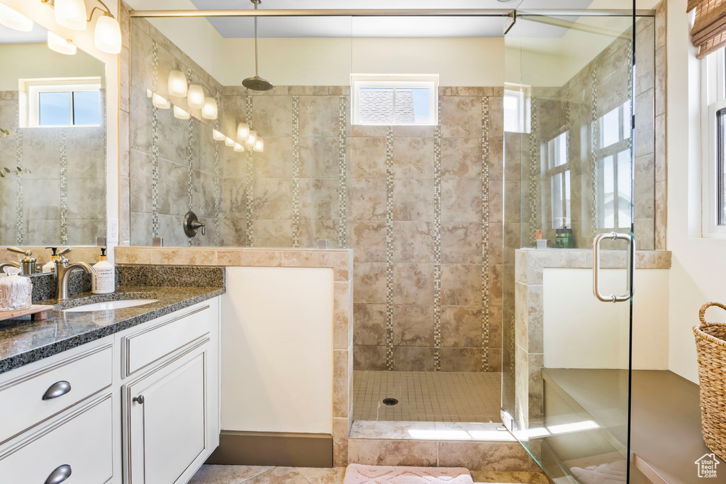 Full bathroom with vanity, a stall shower, and a healthy amount of sunlight