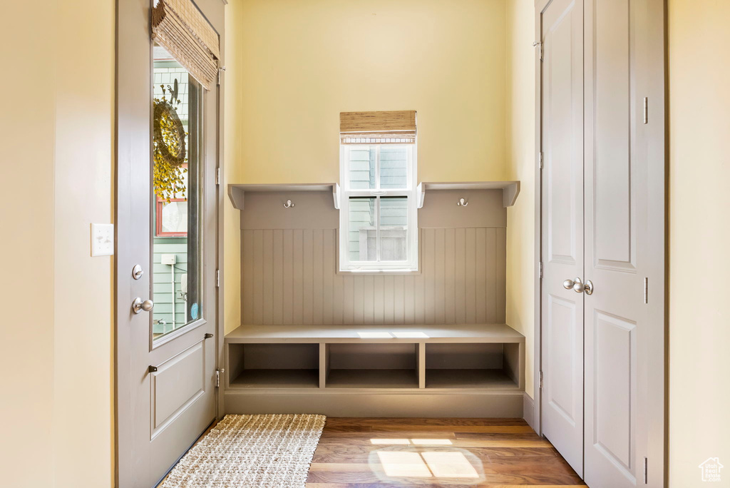Mudroom featuring wooden walls, a wainscoted wall, and wood finished floors