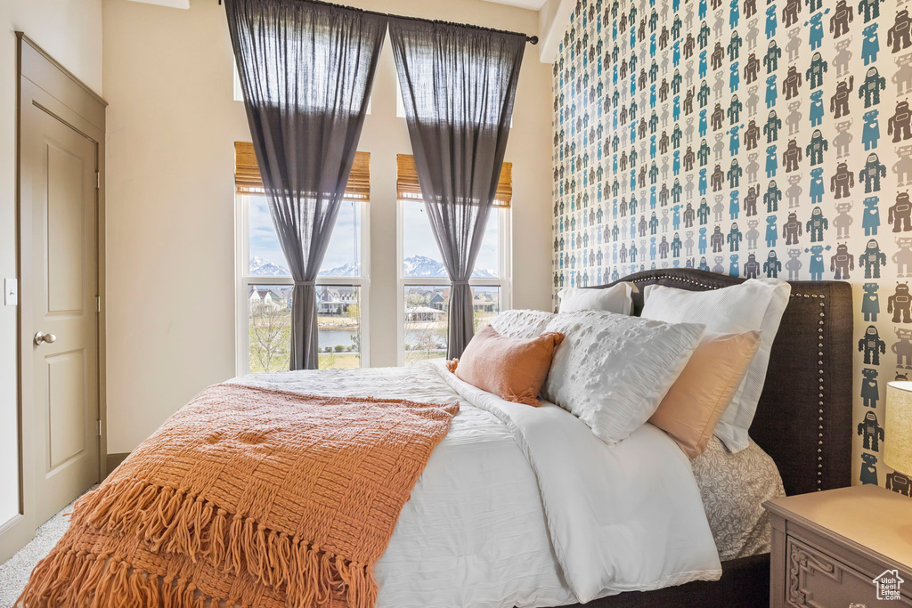 Bedroom featuring a water view and a high ceiling
