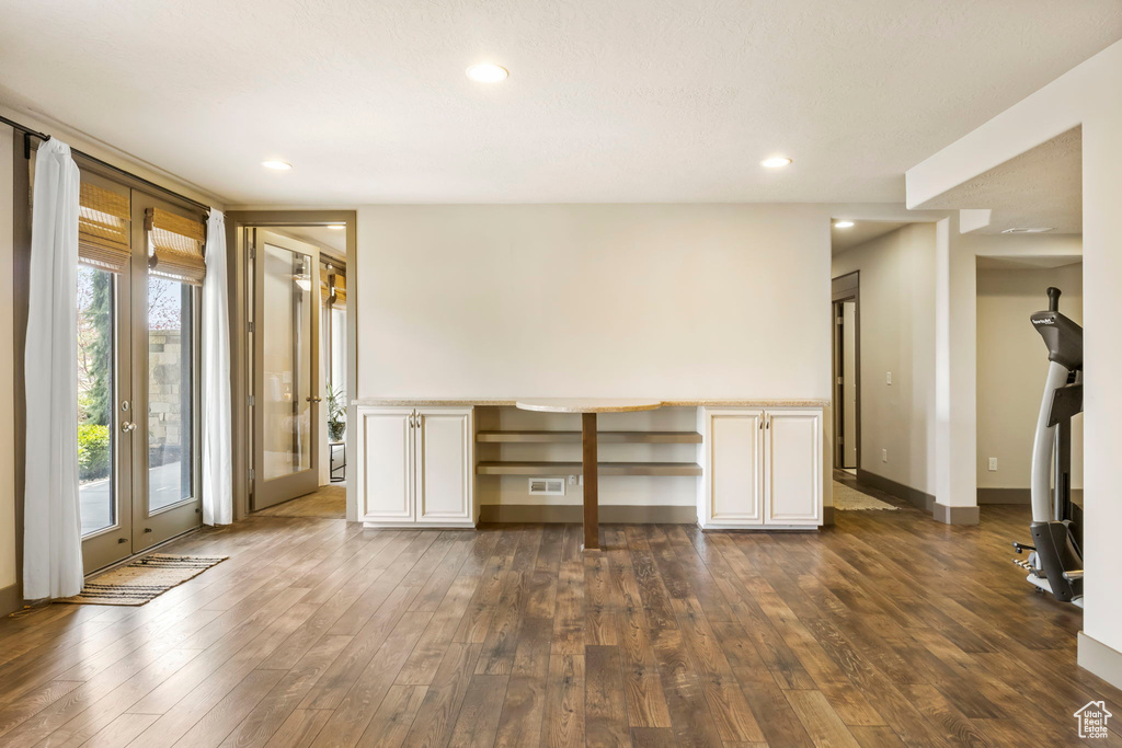 Unfurnished living room featuring visible vents, recessed lighting, dark wood-style flooring, built in study area, and baseboards