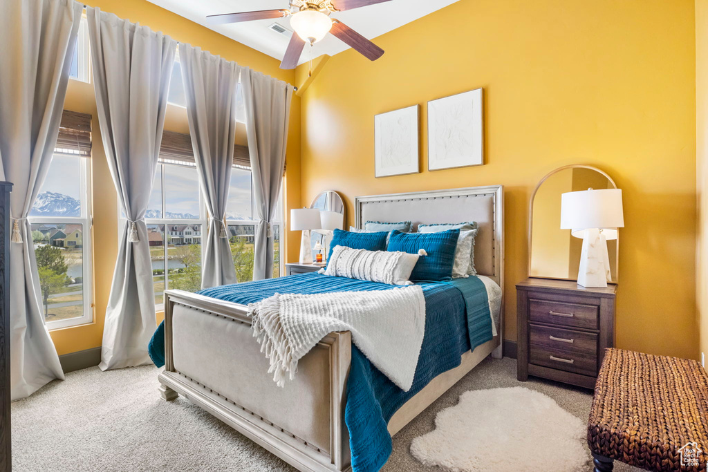 Carpeted bedroom featuring visible vents and a ceiling fan
