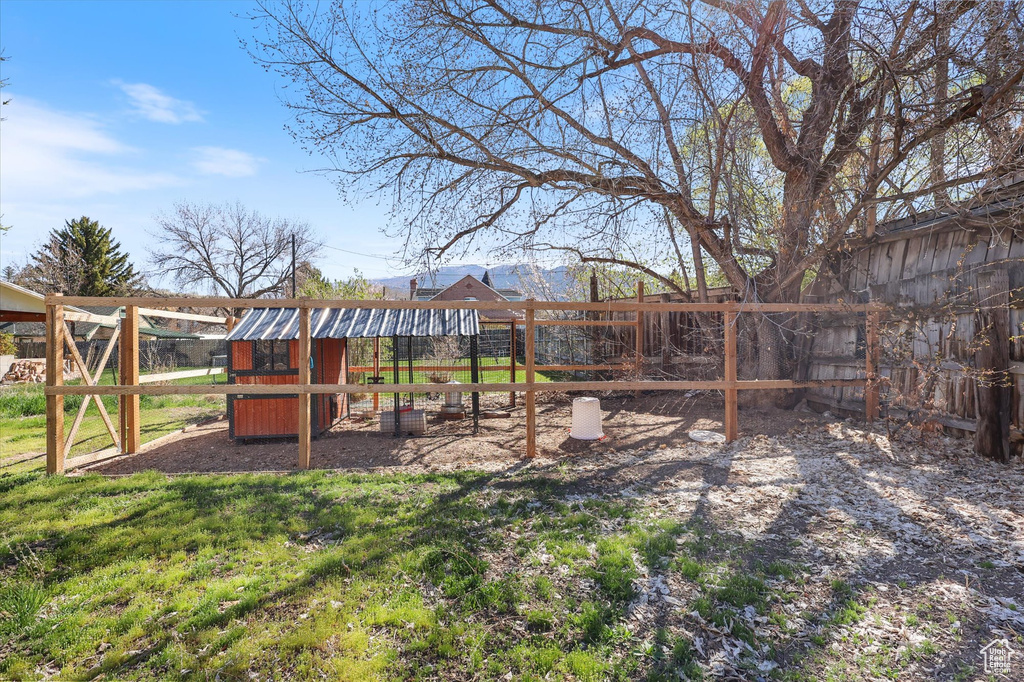 View of yard with exterior structure, fence, and an outdoor structure